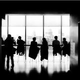 A black and white picture of a corporate meeting.