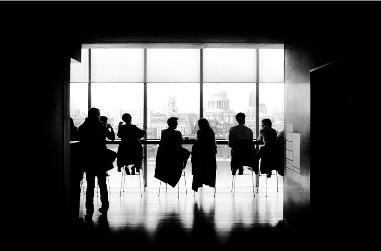 A black and white picture of a corporate meeting.